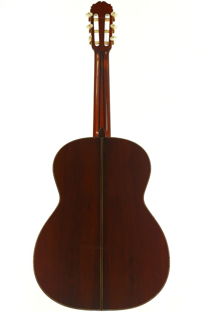 Rückansicht einer Masaru Kohno Professional J Klassische Gitarre aus dem Jahr 1990 mit einem Korpus aus dunklem Holz und einer Kopfplatte mit weißen Stimmwirbeln. Rückansicht einer Masaru Kohno Professional J Klassische Gitarre aus dem Jahr 1990 mit einem Korpus aus dunklem Holz und einer Kopfplatte mit weißen Stimmwirbeln.