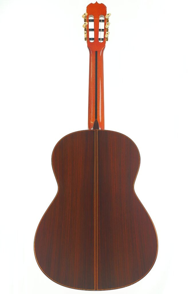 Rückansicht einer Jose Ramirez 1a 2019 C-650 Tradicional Klassische Gitarre, die die dunkle Maserung des Korpus und des Halses zeigt. Rückansicht einer Jose Ramirez 1a 2019 C-650 Tradicional Klassische Gitarre, die die dunkle Maserung des Korpus und des Halses zeigt.
