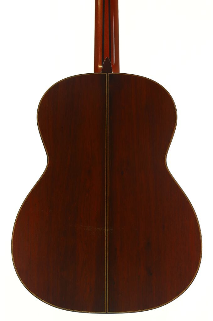Die Rückseite einer Masaru Kohno 1990 Professional J Klassische Gitarre mit einem Korpus aus dunklem Holz und einer Mittelnaht. Die Rückseite einer Masaru Kohno 1990 Professional J Klassische Gitarre mit einem Korpus aus dunklem Holz und einer Mittelnaht.