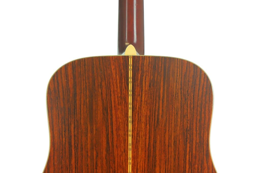 Rückansicht des Korpus einer Martin D-28 Akustikgitarre aus dem Jahr 1975, auf der die Holzmaserung und der mittige Einlegestreifen zu sehen sind. Rückansicht des Korpus einer Martin D-28 Akustikgitarre aus dem Jahr 1975, auf der die Holzmaserung und der mittige Einlegestreifen zu sehen sind.