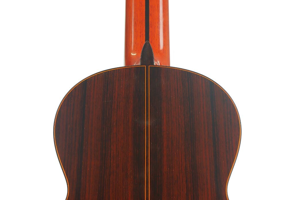 Die Rückansicht einer 8-saitigen klassischen Gitarre von Jose Ramirez aus dem Jahr 1984, die die dunkle Maserung des Korpus und des Halses zeigt. Die Rückansicht einer 8-saitigen klassischen Gitarre von Jose Ramirez aus dem Jahr 1984, die die dunkle Maserung des Korpus und des Halses zeigt.