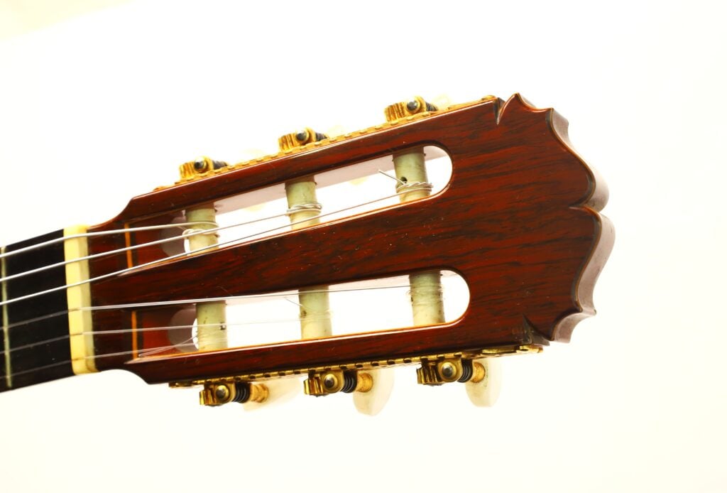 Kopfplatte einer Masaru Kohno 1990 Professional J Klassische Gitarre mit goldenen Stimmmechaniken und weißen Stimmknöpfen. Kopfplatte einer Masaru Kohno 1990 Professional J Klassische Gitarre mit goldenen Stimmmechaniken und weißen Stimmknöpfen.