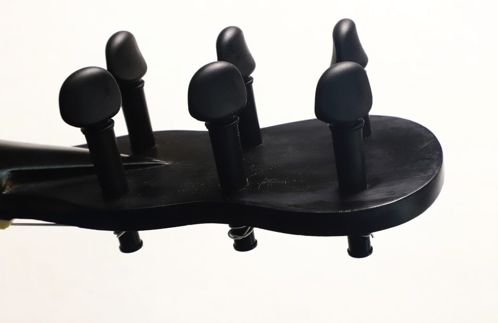 Der schwarze Kopf einer Carlos Gass Castañeda Modell Lacote Romantikgitarre aus dem Jahr 1995 mit sechs schwarzen Stimmwirbeln. Der schwarze Kopf einer Carlos Gass Castañeda Modell Lacote Romantikgitarre aus dem Jahr 1995 mit sechs schwarzen Stimmwirbeln.