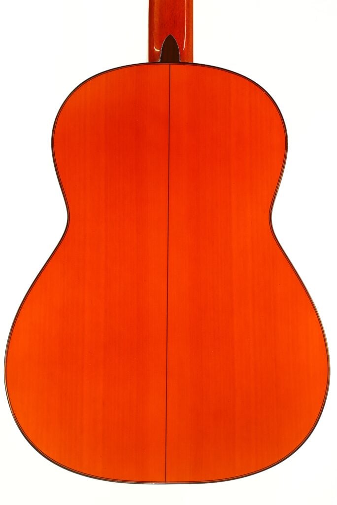 Rückansicht eines orangefarbenen Akustikgitarrenkorpus aus Holz einer Flamenco-Gitarre von Conde Hermanos aus dem Jahr 1989. Rückansicht eines orangefarbenen Akustikgitarrenkorpus aus Holz einer Flamenco-Gitarre von Conde Hermanos aus dem Jahr 1989.