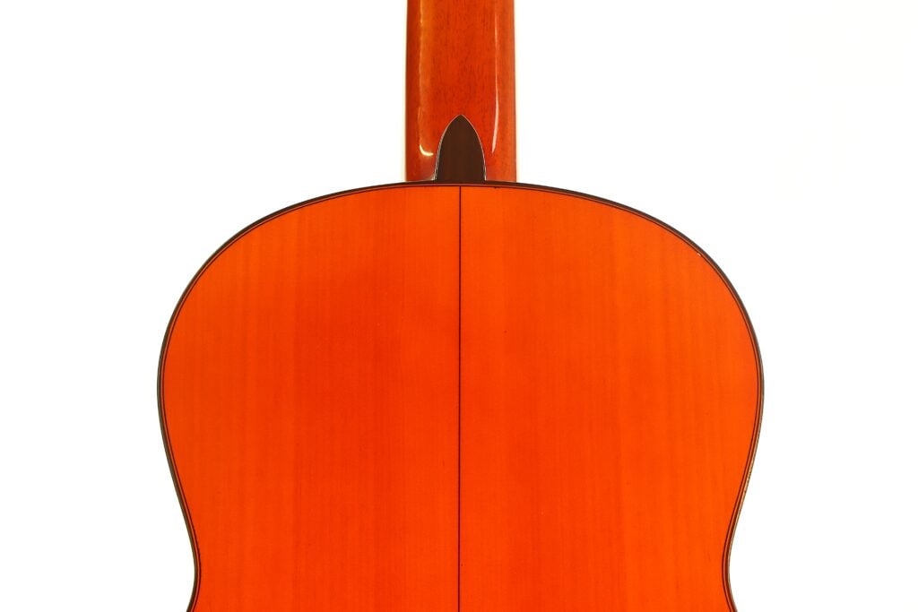Die Rückseite einer Flamenco-Gitarre von Conde Hermanos aus dem Jahr 1989, auf der der Holzkorpus und der Halsfuß zu sehen sind. Die Rückseite einer Flamenco-Gitarre von Conde Hermanos aus dem Jahr 1989, auf der der Holzkorpus und der Halsfuß zu sehen sind.