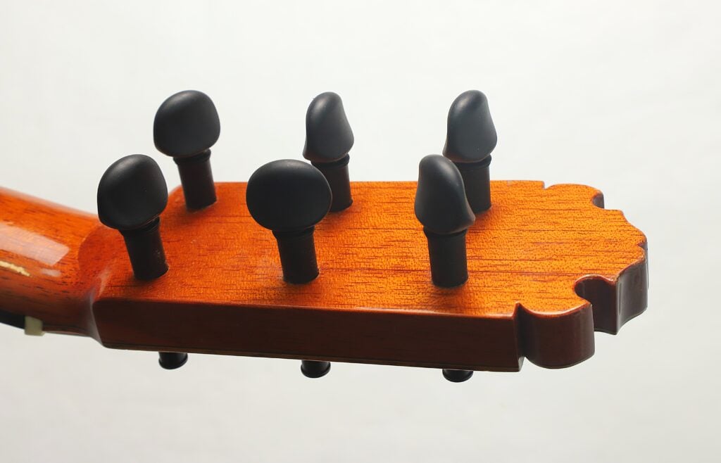 Nahaufnahme des Kopfes einer Flamenco-Gitarre Manuel Contreras 1a 1977 mit sechs schwarzen Stimmwirbeln. Nahaufnahme des Kopfes einer Flamenco-Gitarre Manuel Contreras 1a 1977 mit sechs schwarzen Stimmwirbeln.
