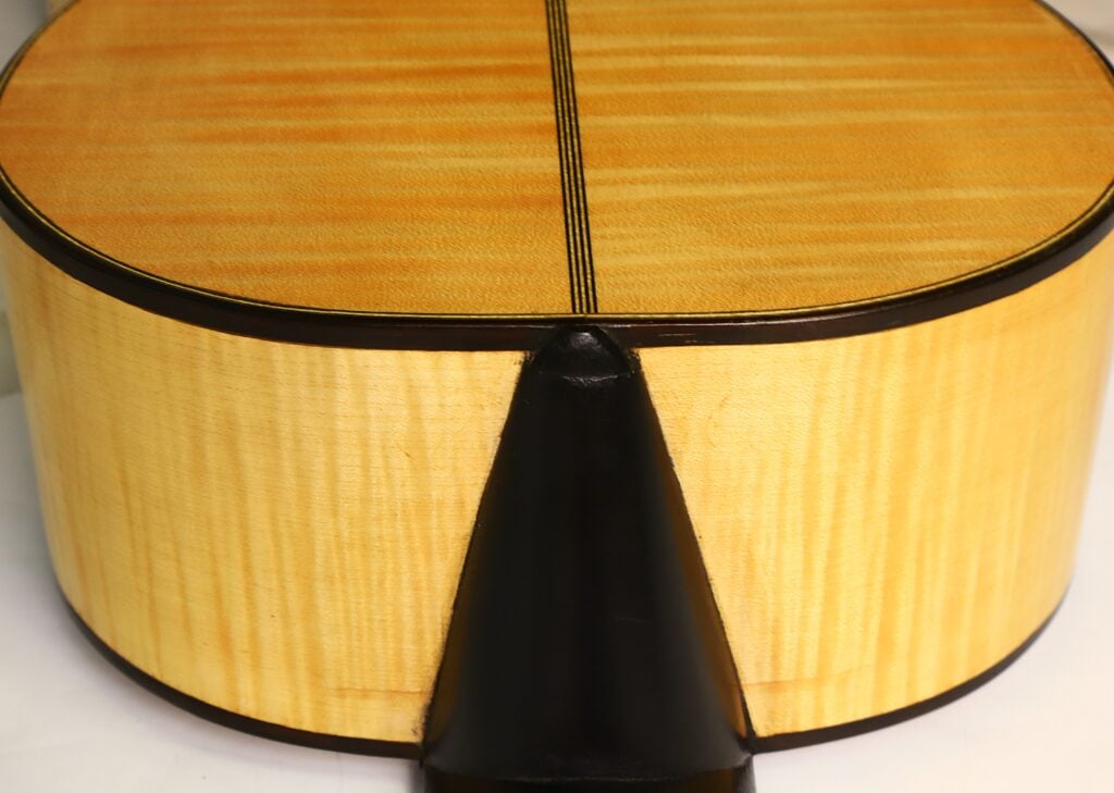 Nahaufnahme des Halsfußes und des Rückens einer akustischen Holzgitarre des Modells Lacote Romantikgitarre von Carlos Gass Castañeda aus dem Jahr 1995. Nahaufnahme des Halsfußes und des Rückens einer akustischen Holzgitarre des Modells Lacote Romantikgitarre von Carlos Gass Castañeda aus dem Jahr 1995.