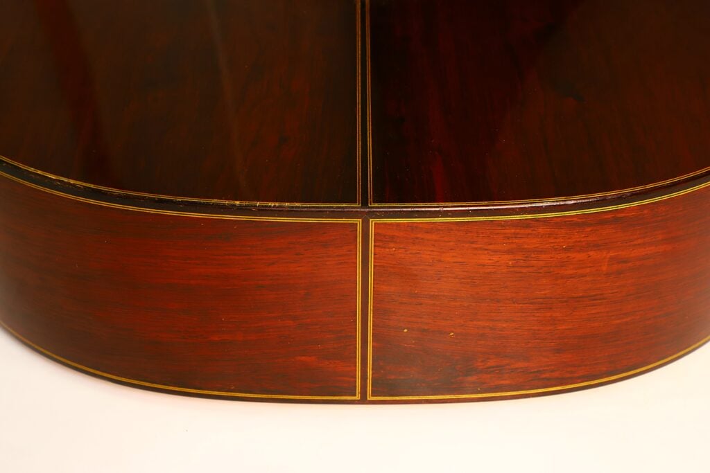 Nahaufnahme der Seiten- und Bodenplatten einer Masaru Kohno 1990 Professional J Klassische Gitarre mit feinen Zierintarsien entlang der Fugen. Nahaufnahme der Seiten- und Bodenplatten einer Masaru Kohno 1990 Professional J Klassische Gitarre mit feinen Zierintarsien entlang der Fugen.