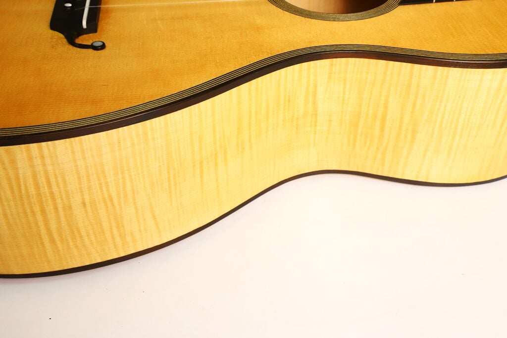 Nahaufnahme des hellen Holzkorpus und der Decke einer Romantikgitarre Modell Lacote von Carlos Gass Castañeda aus dem Jahr 1995. Nahaufnahme des hellen Holzkorpus und der Decke einer Romantikgitarre Modell Lacote von Carlos Gass Castañeda aus dem Jahr 1995.