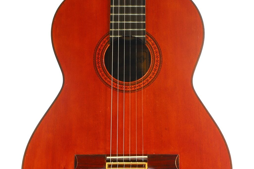 Korpus einer klassischen Gitarre vom Typ Jose Ramirez 1a 1968 mit einer runden Rosette um das Schallloch und sechs Saiten. Korpus einer klassischen Gitarre vom Typ Jose Ramirez 1a 1968 mit einer runden Rosette um das Schallloch und sechs Saiten.