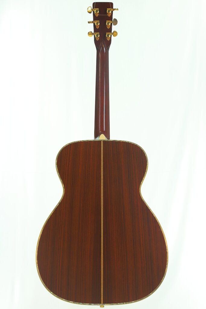 Rückansicht einer Martin SOM-45 Akustikgitarre aus dem Jahr 1977 mit einem Korpus aus dunklem Holz und goldenen Stimmwirbeln. Rückansicht einer Martin SOM-45 Akustikgitarre aus dem Jahr 1977 mit einem Korpus aus dunklem Holz und goldenen Stimmwirbeln.