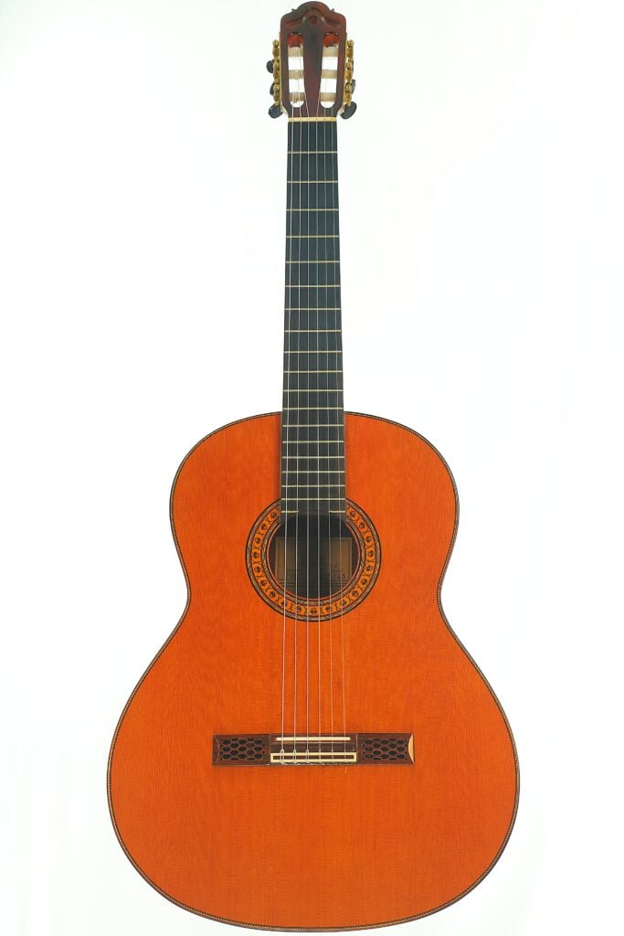 Eine Hopf Gran Concertio 2000 Klassische Gitarre, eine klassische Akustikgitarre mit dunklem Griffbrett und einer kunstvoll verzierten, runden Rosette um das Schallloch. Eine Hopf Gran Concertio 2000 Klassische Gitarre, eine klassische Akustikgitarre mit dunklem Griffbrett und einer kunstvoll verzierten, runden Rosette um das Schallloch.