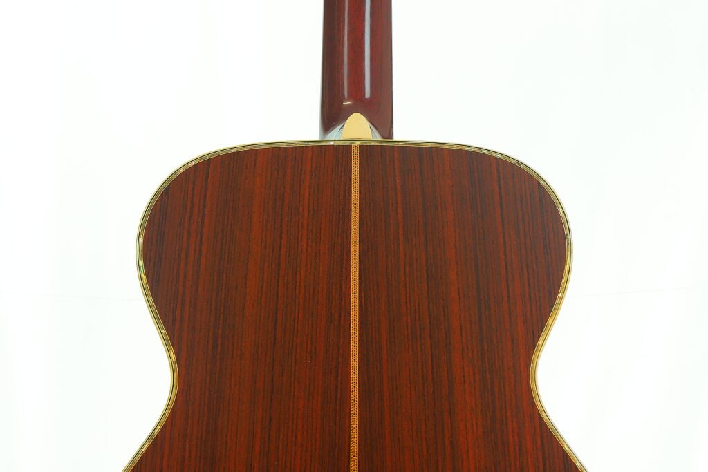 Rückansicht des Korpus einer Martin SOM-45 Akustikgitarre aus dem Jahr 1977, die die dunkle Holzmaserung und die Einlage an der Mittelnaht zeigt. Rückansicht des Korpus einer Martin SOM-45 Akustikgitarre aus dem Jahr 1977, die die dunkle Holzmaserung und die Einlage an der Mittelnaht zeigt.