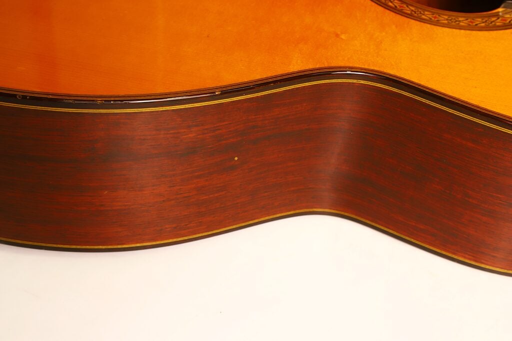 Nahaufnahme der hölzernen Resonanzdecke und der dunklen Rückseite einer Masaru Kohno 1990 Professional J Klassische Gitarre. Nahaufnahme der hölzernen Resonanzdecke und der dunklen Rückseite einer Masaru Kohno 1990 Professional J Klassische Gitarre.