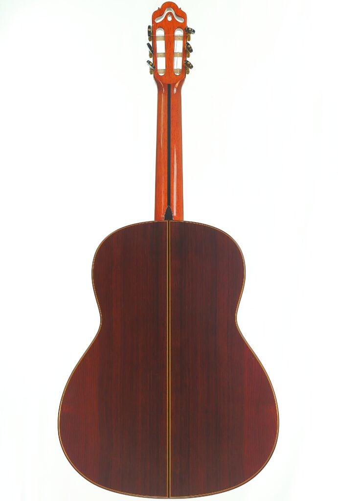 Die Rückansicht einer Hopf Gran Concertio 2000 Klassische Gitarre mit einem Korpus aus dunklem Holz und einem Hals aus hellem Holz mit verziertem Kopf. Die Rückansicht einer Hopf Gran Concertio 2000 Klassische Gitarre mit einem Korpus aus dunklem Holz und einem Hals aus hellem Holz mit verziertem Kopf.