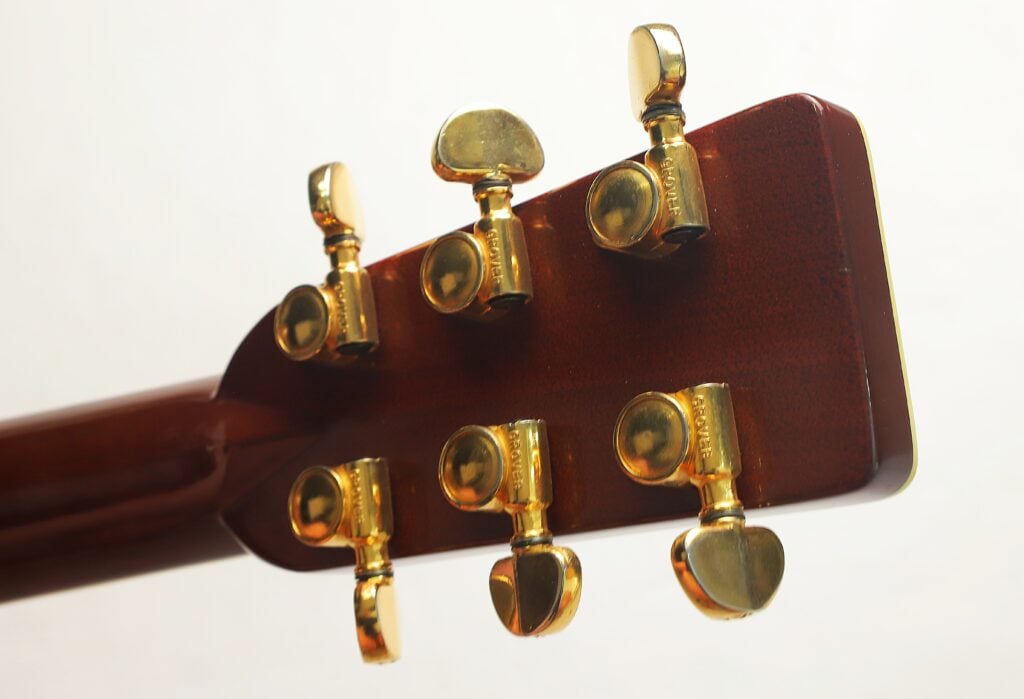 Rückansicht des Kopfes der Martin SOM-45 Akustikgitarre aus dem Jahr 1977 mit sechs goldenen Stimmwirbeln. Rückansicht des Kopfes der Martin SOM-45 Akustikgitarre aus dem Jahr 1977 mit sechs goldenen Stimmwirbeln.