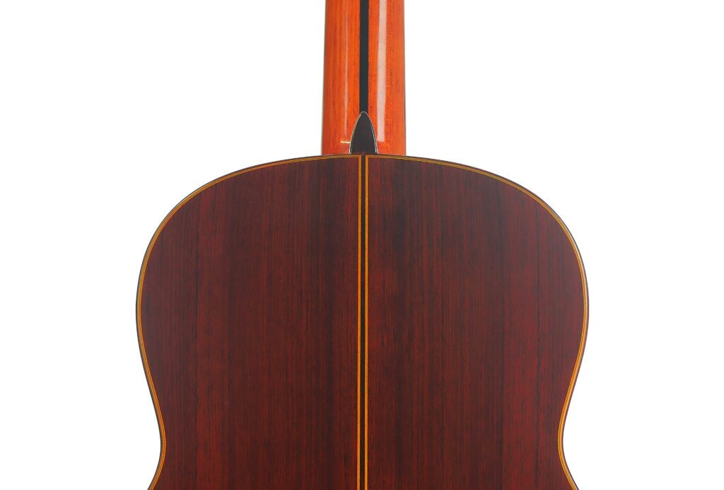 Rückansicht des Korpus der Hopf Gran Concertio 2000 Klassische Gitarre mit dunkler Holzmaserung und einer Mittellinie. Rückansicht des Korpus der Hopf Gran Concertio 2000 Klassische Gitarre mit dunkler Holzmaserung und einer Mittellinie.