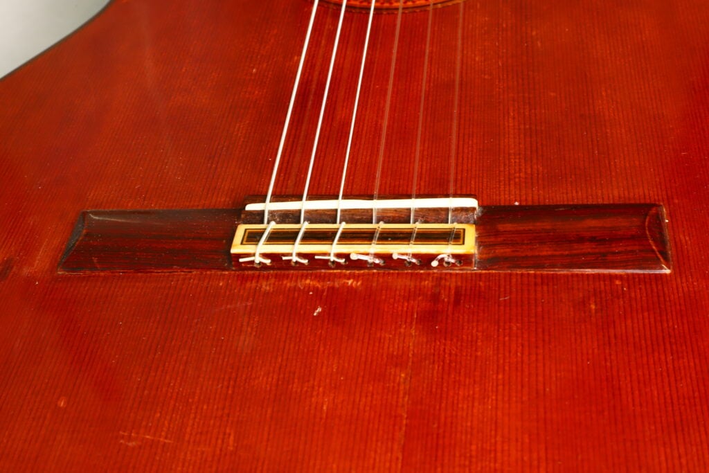Nahaufnahme des Stegs und der Nylonsaiten der Jose Ramirez 1a 1968 Klassische Gitarre aus Holz. Nahaufnahme des Stegs und der Nylonsaiten der Jose Ramirez 1a 1968 Klassische Gitarre aus Holz.