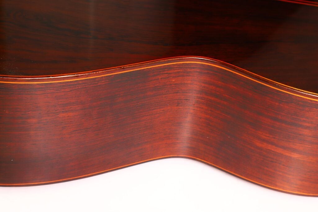 Nahaufnahme der polierten, dunklen Holzseite und des Pols einer Jose Ramirez 1a 1968 Klassische Gitarre. Nahaufnahme der polierten, dunklen Holzseite und des Pols einer Jose Ramirez 1a 1968 Klassische Gitarre.