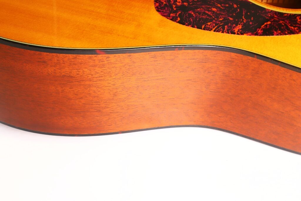 Nahaufnahme der Holzseite und der Decke einer Martin D-18 VS 2006 Akustikgitarre mit einem Pickguard aus Schildpatt. Nahaufnahme der Holzseite und der Decke einer Martin D-18 VS 2006 Akustikgitarre mit einem Pickguard aus Schildpatt.