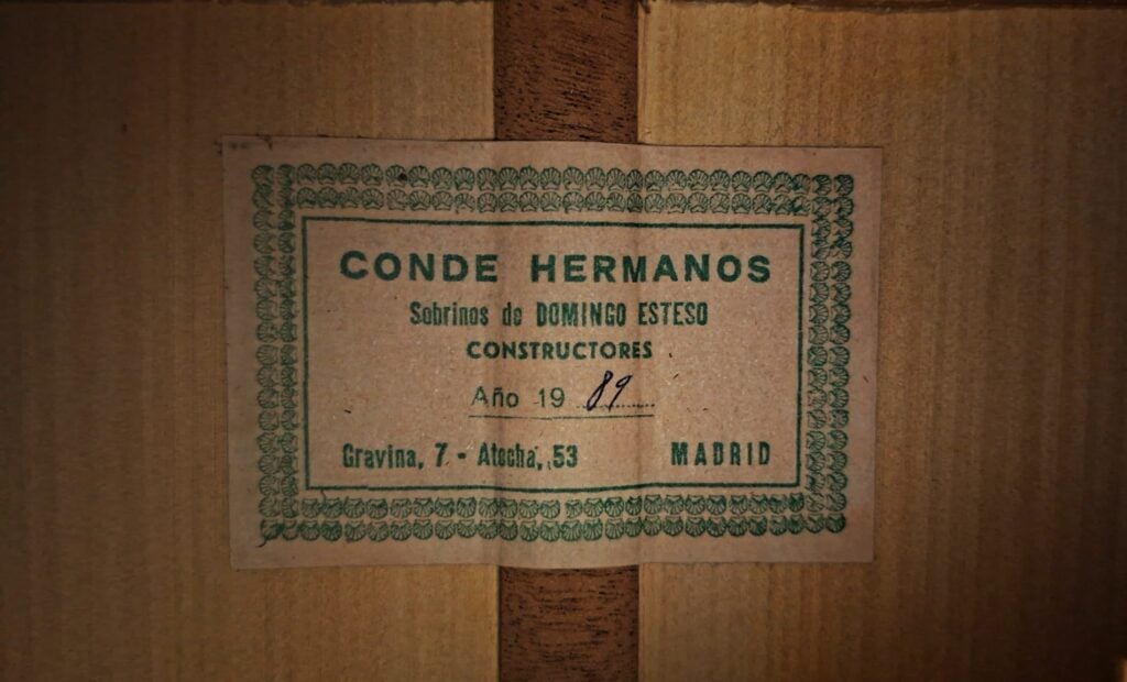 Auf dem grün umrandeten Etikett im Schallloch einer Flamenco-Gitarre von Conde Hermanos aus dem Jahr 1989 steht: CONDE HERMANOS, Sobrinos de DOMINGO ESTESO, CONSTRUCTORES, Año 19 89 und Gravina, 7 – Atocha, 53 MADRID. Auf dem grün umrandeten Etikett im Schallloch einer Flamenco-Gitarre von Conde Hermanos aus dem Jahr 1989 steht: CONDE HERMANOS, Sobrinos de DOMINGO ESTESO, CONSTRUCTORES, Año 19 89 und Gravina, 7 – Atocha, 53 MADRID.