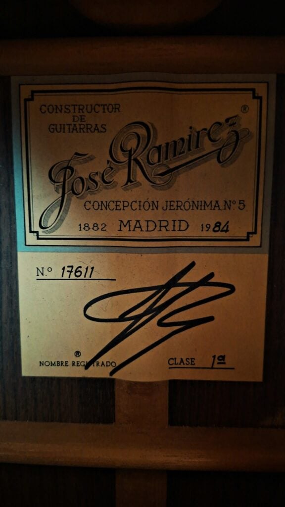 Ein Etikett einer 8-saitigen klassischen Gitarre von Jose Ramirez aus dem Jahr 1984, auf dem der Name des Herstellers, die Adresse in Madrid, das Jahr 1984, die Seriennummer 17611 und eine Unterschrift zu sehen sind. Ein Etikett einer 8-saitigen klassischen Gitarre von Jose Ramirez aus dem Jahr 1984, auf dem der Name des Herstellers, die Adresse in Madrid, das Jahr 1984, die Seriennummer 17611 und eine Unterschrift zu sehen sind.