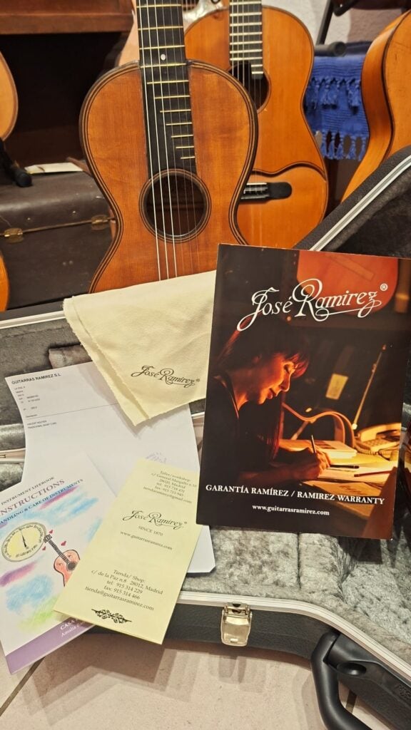 Eine Jose Ramirez 1a 2019 C-650 Tradicional Klassische Gitarre in ihrem offenen Hartschalenkoffer, zusammen mit einem Garantieschein, einer Visitenkarte und Informationsunterlagen. Eine Jose Ramirez 1a 2019 C-650 Tradicional Klassische Gitarre in ihrem offenen Hartschalenkoffer, zusammen mit einem Garantieschein, einer Visitenkarte und Informationsunterlagen.